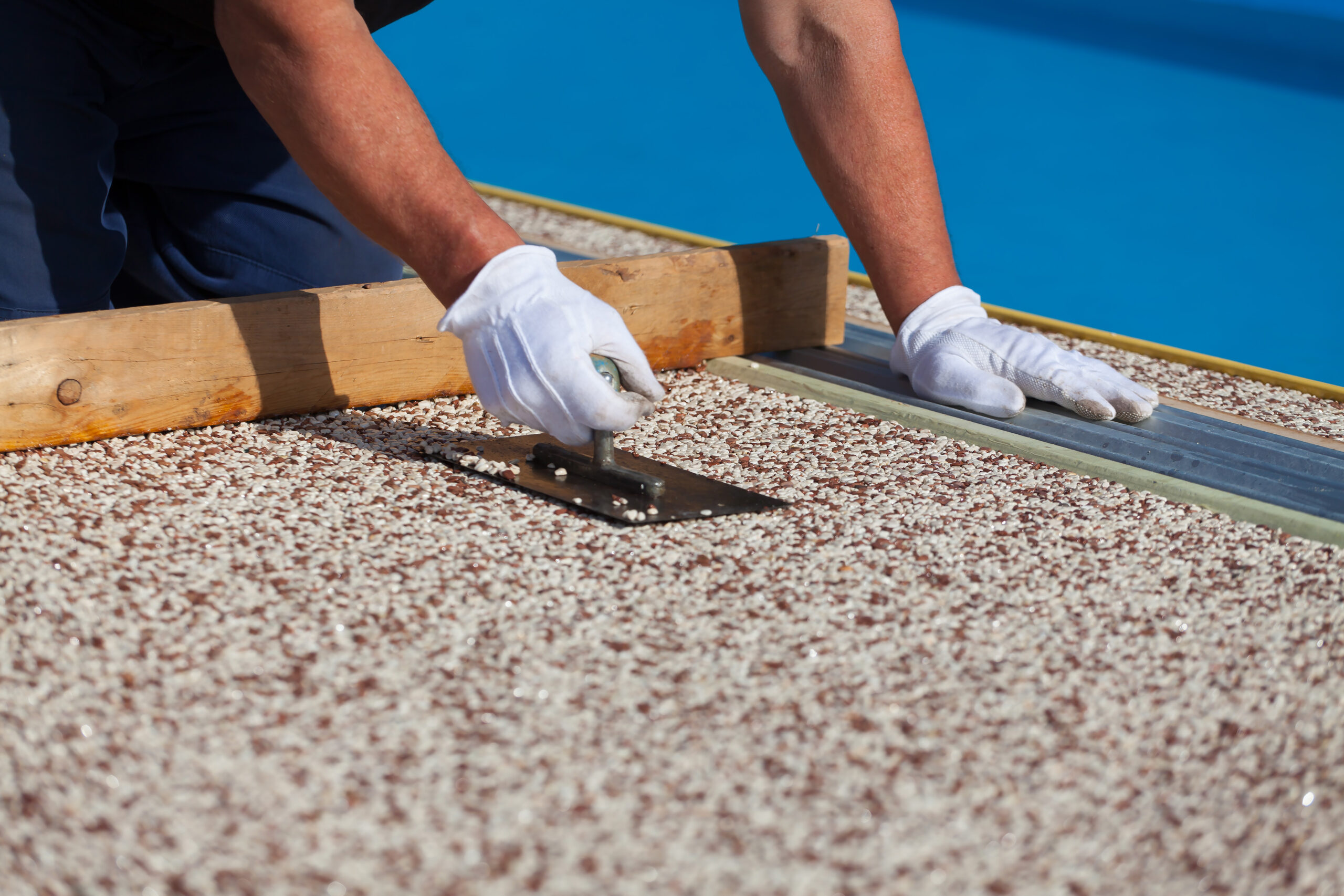 The worker places a stone carpet with resin.
(Shallow DOF).